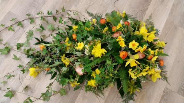 Bright woodland flower and wild foliage single ended funeral coffin spray