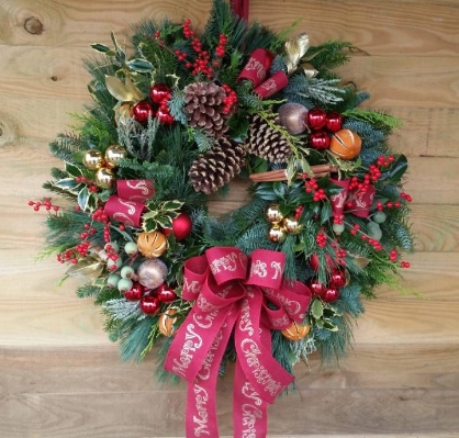 Large christmas door wreath made from evergreen and traditional decoration