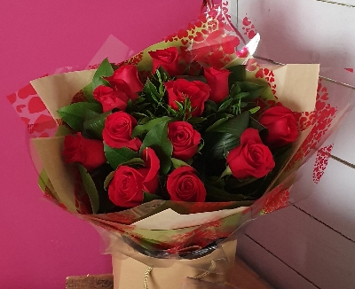 The Classic Dozen of red roses and foliage in a presentation bag