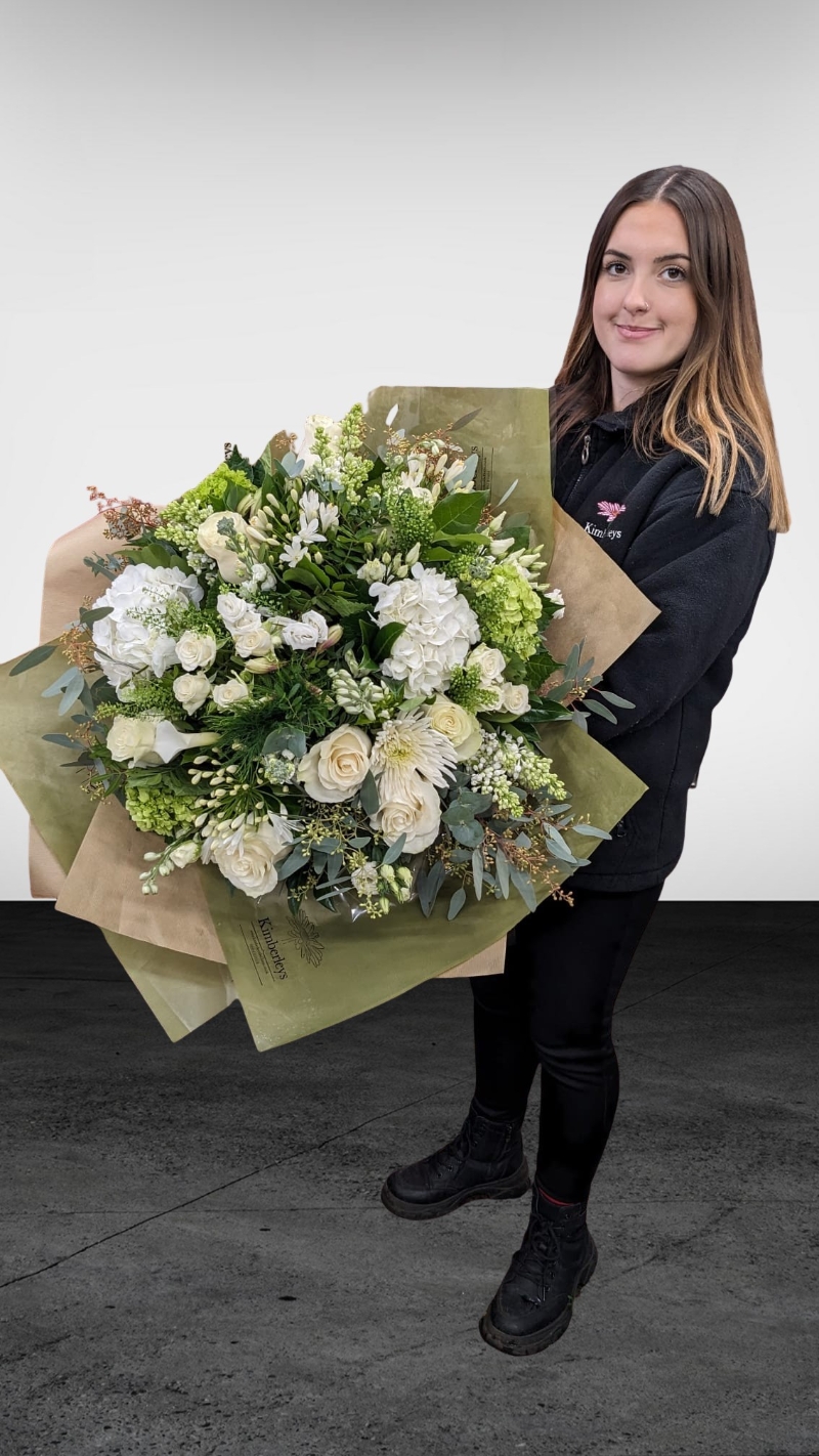 large white and green flower and foliage handtied bouquet in a vase