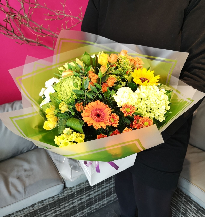 yellow and orange flower handtied bouquet in a gift bag