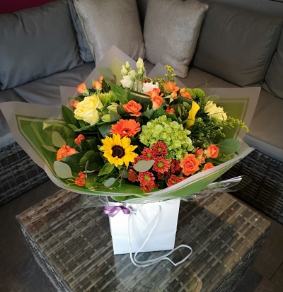 yellow and orange flower handtied bouquet in a gift bag