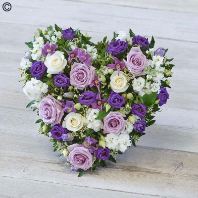 Lilac and white flower and foliage heart shaped funeral tribute