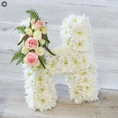 white based flower funeral tribute letter with pink spray