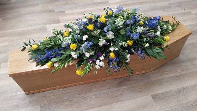  Yellow roses, blue delphiniums, purple and white flower and mixed foliage double ended funeral coffin spray