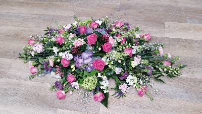 Pink, lilac and white flower and foliage double ended funeral coffin spray with roses and hydrandea 