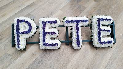 White based chrysanthemum letter funeral tribute with line of coloured flowers in the centre, can be edged with coloured ribbon or foliage