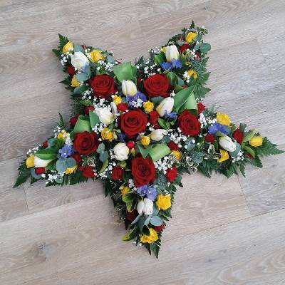 Bright rose flower and foliage star funeral tribute 