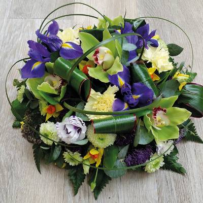 Contemporary green orchid and blue iris funeral tribute flower and foliage posy