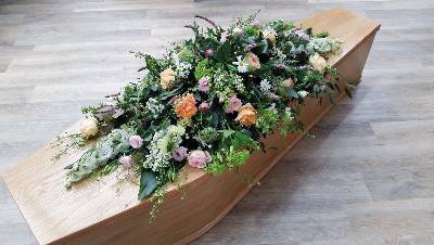 country pastels, peach, pink roses, blue and white flower and foliage double ended funeral coffin spray 