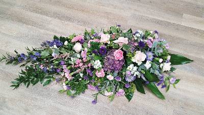 Country style pink, purple and lilac flower and foliage single ended funeral coffin spray 