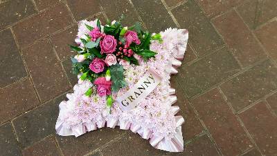 Pink chrysanthemum based cushion funeral flower tribute with ribbon 