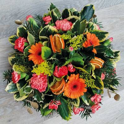 Seasonal spring orange flower and foliage posy funeral tribute