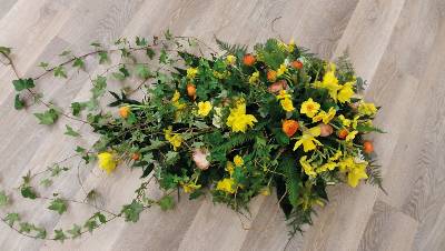 Bright woodland flower and wild foliage single ended funeral coffin spray 