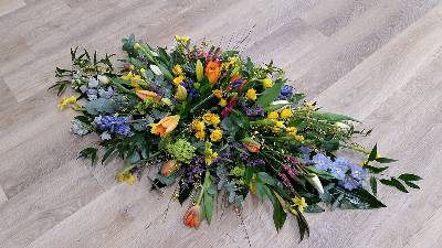 Bright spring and seasonal flower and foliage double ended funeral coffin spray 