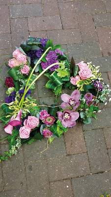 Pastel pink and purple flower and foliage open heart funeral tribute 