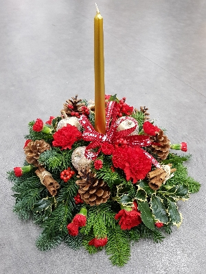 red and gold christmas flower and foliage table centre piece with candle 