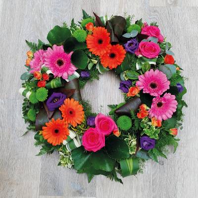 Bright and modern flower and foliage funeral tribute wreath 