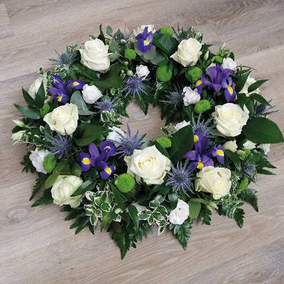 White and blue flower and foliage funeral tribute wreath 