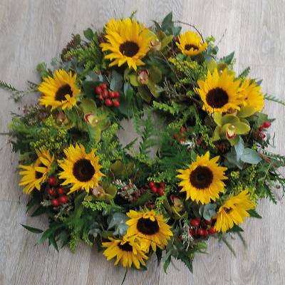 Wild yellow flower and foliage funeral tribute wreath with sunflower and berries 