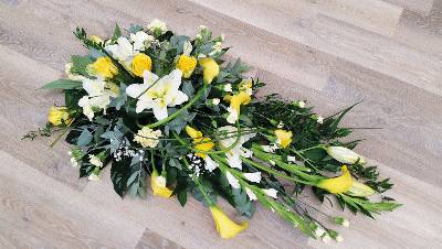 Yellow and white flower and foliage single ended funeral coffin spray with roses and lilies 