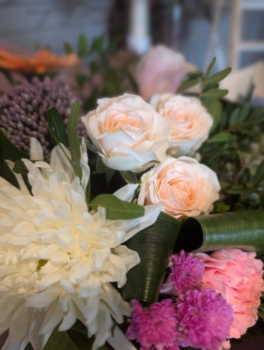 pink and purple handtied flower bouquet in a gift bag