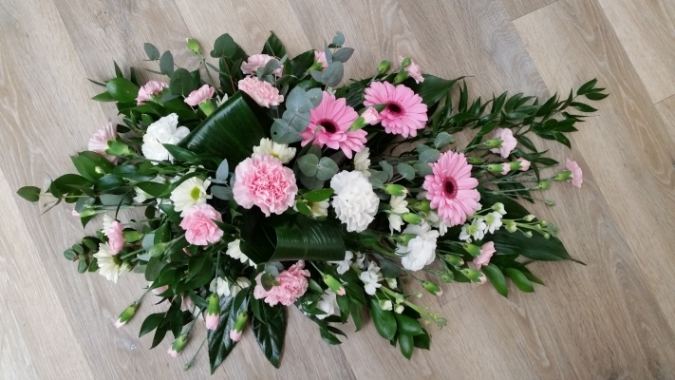 Single-ended coffin spray with pretty pinks and white scented stocks, pastel pink gerberas and baby pink carnations.