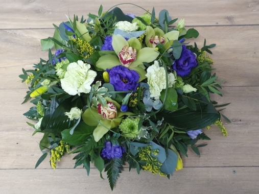 Contemporary green orchid and blue iris funeral tribute flower and foliage posy