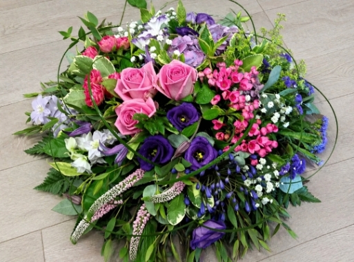 A modern style grouped posy of pretty pink roses, textured veronica and velvet purple lisianthus with a combination of delicate complimenting blooms.