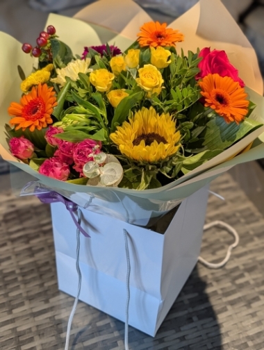 Rich and vibrant autumnal flowers in a gift bag