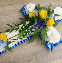 Blue, yellow and white based chrysanthemum cross funeral flower tribute 