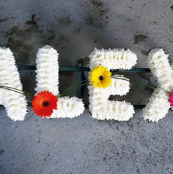 Simple white based chrysanthemum letter funeral tribute with flower and grass linking each letter