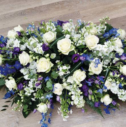 White rose and blue delphinium flower and foliage double ended funeral coffin spray 