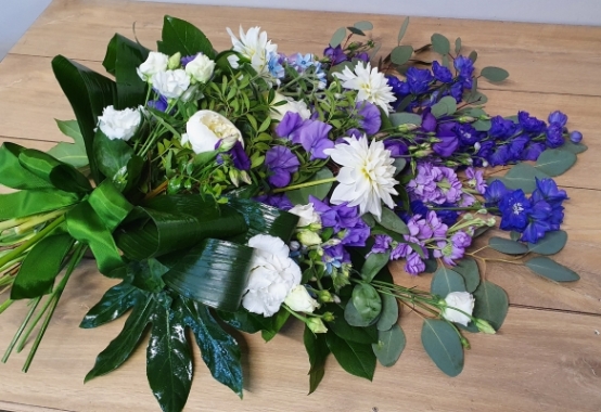 Hand-tied sheaf with lilac and blue blooms, dahlia , white peonies when in season, scented stocks and double white lisianthus and mixed green foliage.