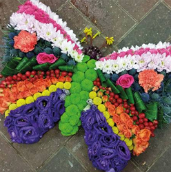 Vibrant flower and foliage butterfly funeral tribute