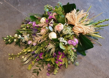 A hand-tied country mix sheaf with textured veronica, scented stocks and phlox, beautiful roses, long white delphinium, pale pink astilbe and country foliage.