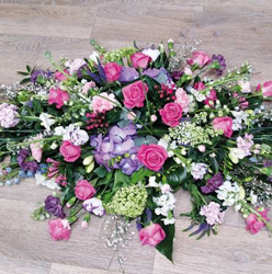 Pink, lilac and white flower and foliage double ended funeral coffin spray with roses and hydrandea 