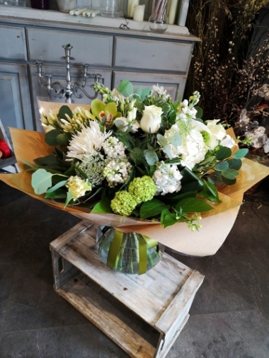 large white and green flower and foliage handtied bouquet in a vase