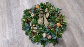 christmas foliage door wreath with bow and waxed fruit
