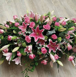Pink rose and lily mixed foliage and flower double ended funeral coffin spray 
