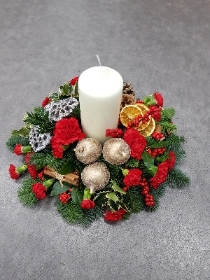 red and gold christmas flower and foliage table centre piece with candle 