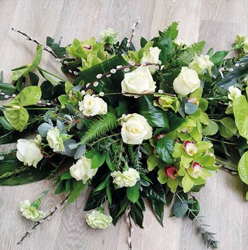 Modern flower and foliage double ended funeral coffin spray with orchids, anthuriums and roses