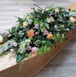 country pastels, peach, pink roses, blue and white flower and foliage double ended funeral coffin spray 