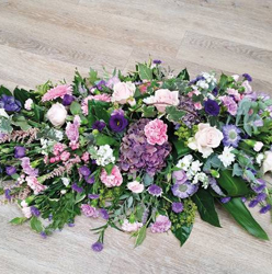 Country style pink, purple and lilac flower and foliage single ended funeral coffin spray 