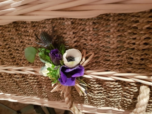 A rustic spray placed on each coffin handle of anemone and thistle 