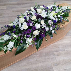 Purple and white lily and rose scented flower and foliage double ended funeral coffin spray 