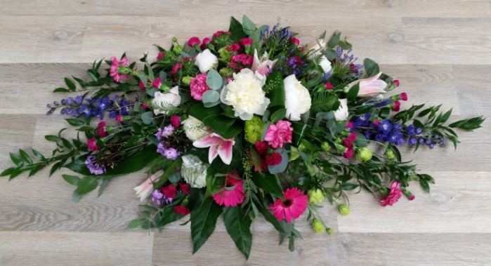 This double-ended arrangement features a mix of pink and white blooms, lilies, gerberas, purple delphiniums and lush greenery