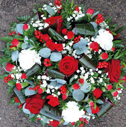 Red and white funeral tribute flower and foliage posy with roses and gypsophila 