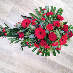 Red gerbera and rose single ended flower and foliage funeral coffin spray