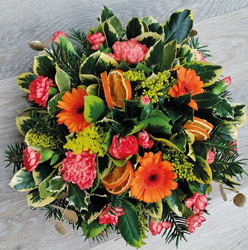 Seasonal spring orange flower and foliage posy funeral tribute